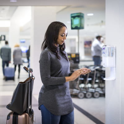 PURELL ES6 hand sanitizer dispenser being used at airport baggage claim