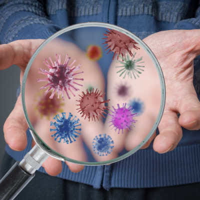 Man holding hands palm up with a graphic of magnifying glass looking at germs